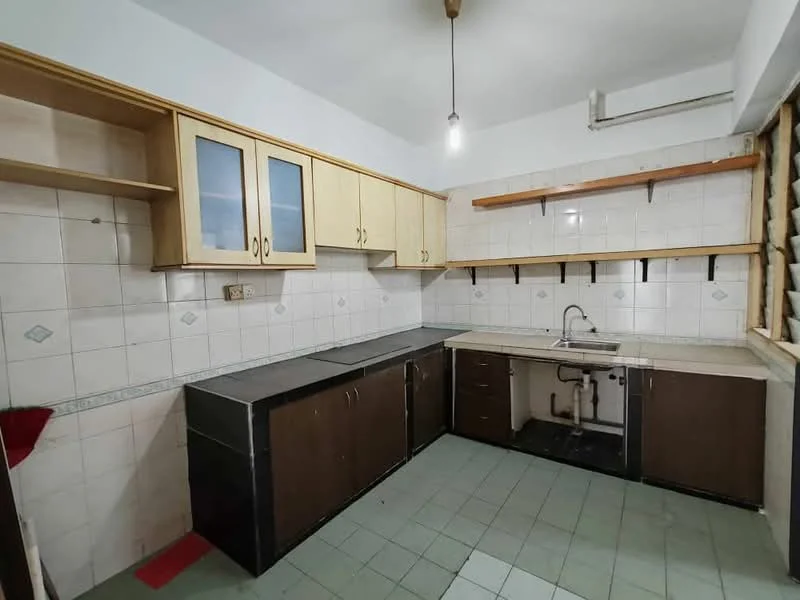 Kitchen features: laminate cabinetry in light wood, dark laminate lower cabinets, black countertop, single-bowl stainless-steel sink, chrome faucet, wall-mounted air conditioning unit, white tiled walls, green tiled flooring, open shelving above countertop, light fixture with exposed bulb.
