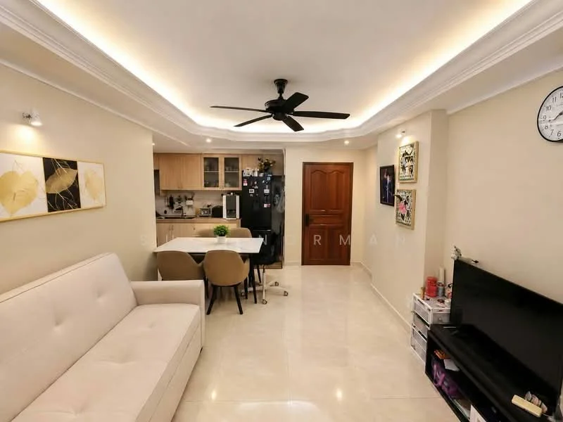 Living features: cream painted walls, white ceiling with recessed lighting, 5-blade ceiling fan with light, marble tile flooring, 3-seater fabric sofa in beige, wall-mounted TV, TV console, decorative wall clock, framed artwork, dining table with chairs, kitchenette with wooden cabinetry, black refrigerator; style: modern.
