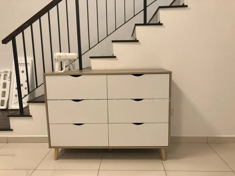 Room features: white dresser with six drawers, wooden legs, neutral wall colour, tile flooring, staircase in background, black metal railing, decorative sewing machine on top; style: modern.