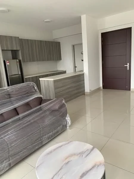 Living features: grey fabric sofa wrapped in plastic, round marble coffee table, light-colored tiled flooring, white painted walls, kitchen cabinetry with wood finish, stainless-steel fridge, open kitchen layout, recessed ceiling lights, door leading to another room; style: modern.