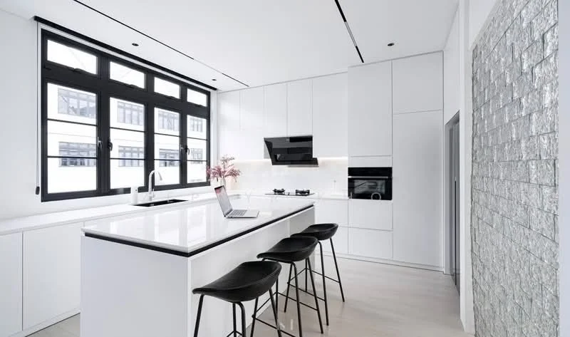Kitchen features: white cabinetry, white quartz countertop, black bar stools, stainless-steel sink, chrome pull-down faucet, built-in oven, gas hob, black range hood, recessed downlights, floor-to-ceiling windows, light wood flooring, textured stone accent wall; style: modern.