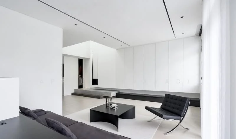 Living features: white painted walls, light grey flooring, recessed downlights, large windows with sheer curtains, minimalist black coffee table, black lounge chair, built-in cabinetry, open layout, contemporary design, neutral color palette; style: modern.
