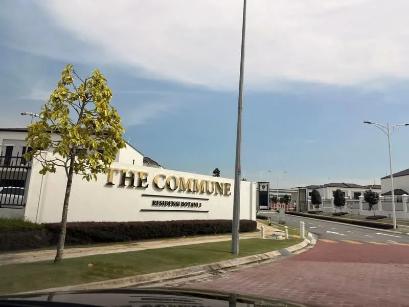 Exterior type: linked terrace house; features: white painted facade, landscaped garden, manicured lawn, paved walkway, street lighting, signage for The Commune, surrounding greenery, residential street view; style: modern.