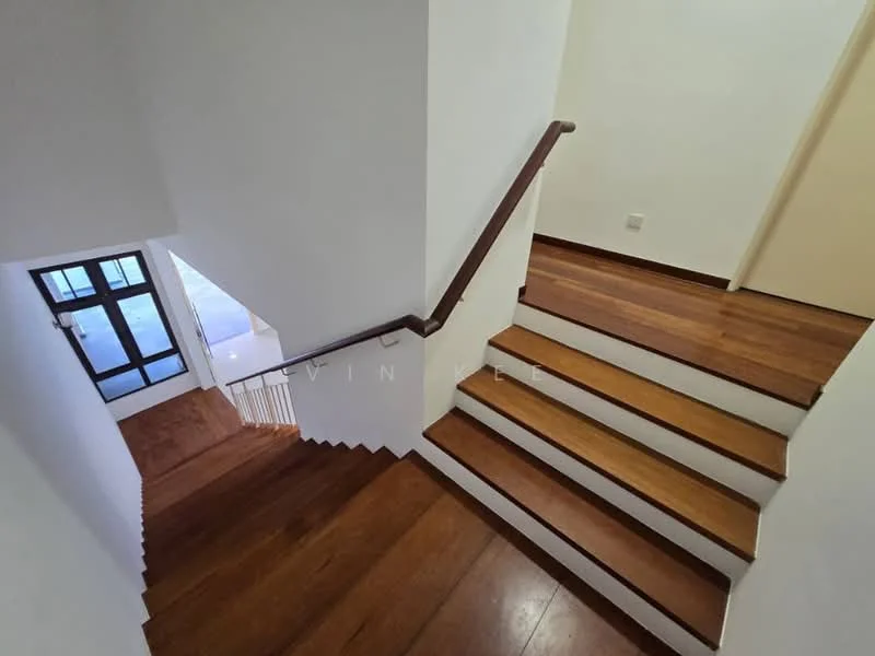 Room features: wooden staircase, dark wood handrail, white painted walls, laminate flooring, natural light from windows, open space, stair landing, doorway at the bottom of stairs; style: modern.