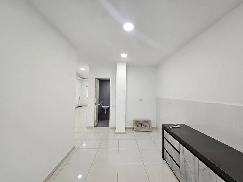 Room features: white painted walls, glossy white floor tiles, recessed LED downlights, black countertop, grey cabinetry, doorway leading to another room, empty space, no visible appliances; style: modern.