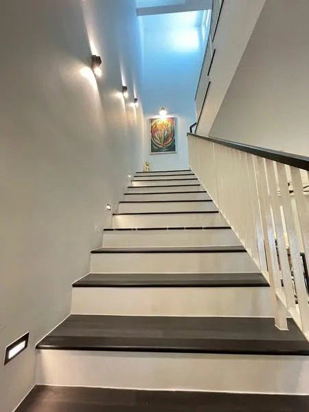 Room features: staircase with wooden steps, white painted walls, recessed wall lighting, decorative artwork on wall, handrail, light-colored ceiling, open space at the top of the stairs; style: modern.