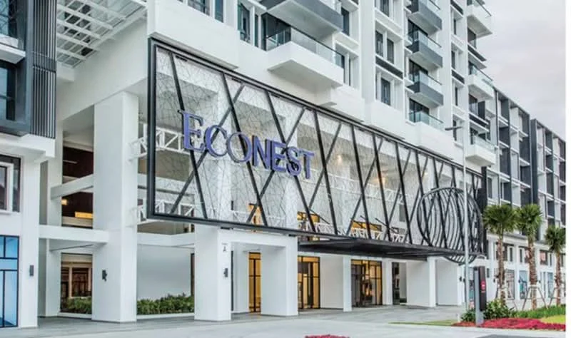 Exterior type: mid-rise condominium; features: glass curtain wall, white painted facade, decorative lattice design, entrance canopy, landscaped entrance with flower beds, balconies on upper floors, modern architectural design; style: contemporary.