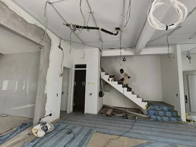 Room features: unfinished walls, exposed electrical wiring, staircase with no railing, grey concrete wall, white painted walls, blue carpet flooring, construction debris on floor, ceiling with hanging wires.