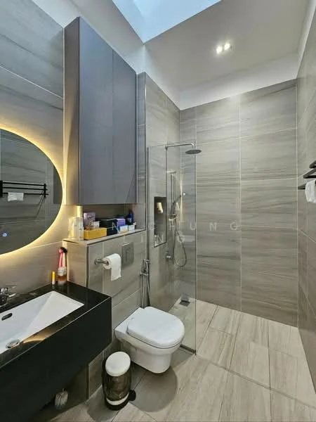 Bathroom features: grey tiled walls, light grey tiled flooring, walk-in shower with glass enclosure, rain shower head, handheld shower, single-sink vanity with black cabinet, round backlit mirror, chrome basin mixer faucet, one-piece toilet, towel rack, wall-mounted shelving; style: modern.