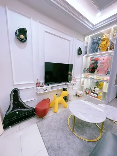 Living features: white painted walls, tray ceiling, marble coffee table, grey area rug, black entertainment unit, wall-mounted TV, decorative shelves with collectibles, yellow decorative dog sculpture, red ottoman, LED lighting in shelves; style: modern.