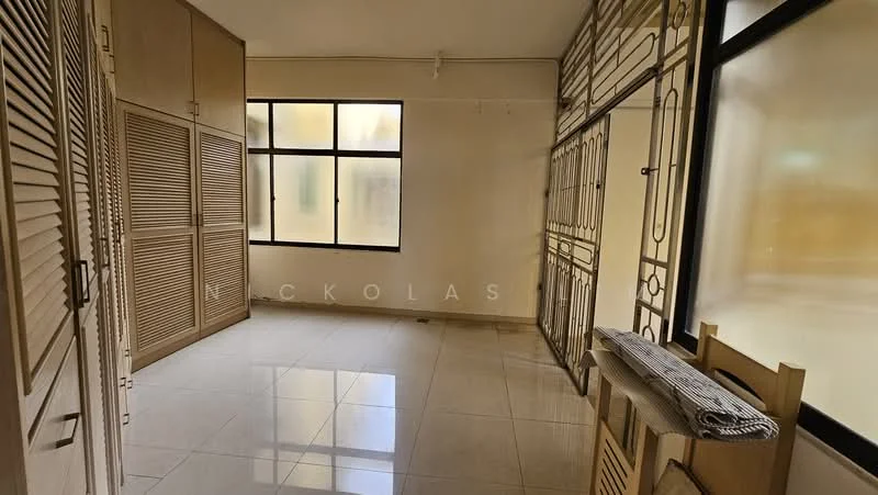 Room features: cream painted walls, white tiled flooring, large windows with black frames, built-in cabinetry with louvered doors, open shelving unit, neutral color scheme, ceiling light fixture, corner space for furniture; style: modern.