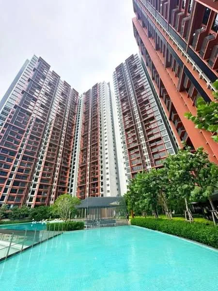 Exterior type: high-rise condominium; features: glass curtain wall, red brick facade, approximately 20-storey high-rise, infinity pool, pool deck with loungers, manicured lawn, mature trees, tropical landscaping, gated entry, guard house at entrance; style: modern.