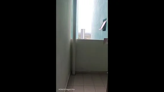 Room features: light blue painted walls, tile flooring, window with view, balcony railing, natural light.