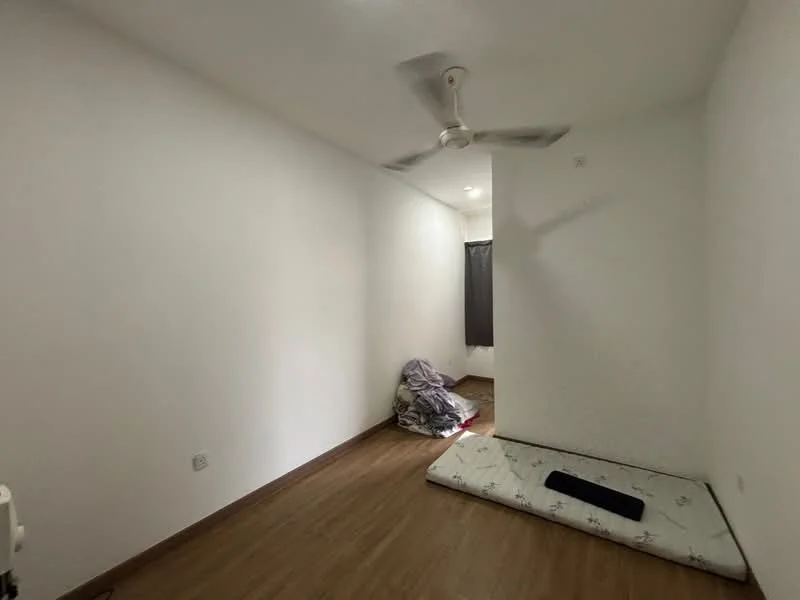 Room features: white painted walls, wooden flooring, ceiling fan, window with grey curtain, mattress on the floor, bedding on the floor, light fixture on ceiling.