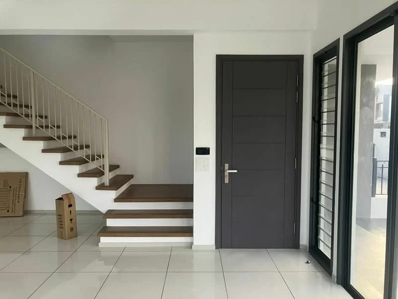Room features: white painted walls, light-colored tiled flooring, wooden staircase with white railing, dark wood door, large glass sliding door, intercom panel, cardboard boxes on the floor; style: modern.
