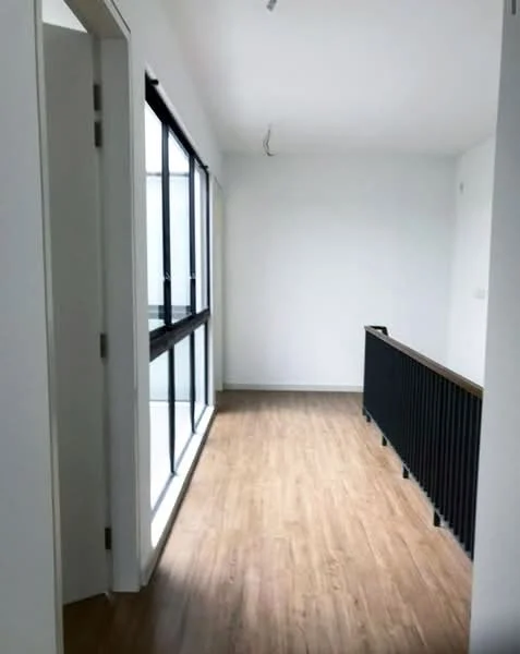 Room features: white painted walls, laminate wood flooring, floor-to-ceiling windows, black railing, natural light from windows; style: modern.