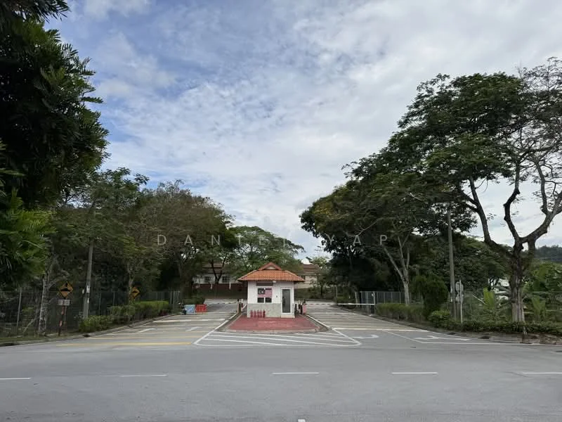 Exterior type: main entrance gate; features: guard house at entrance, paved driveway, surrounded by mature trees, fenced perimeter, road markings, landscaped greenery; style: modern.