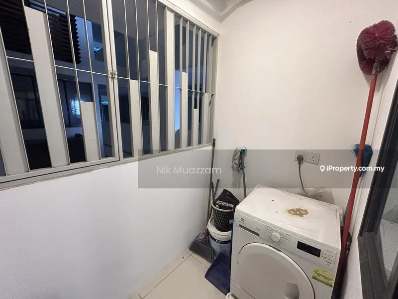Laundry features: white front-load washing machine, grey tiled flooring, white painted walls, metal window grills, single-basin sink, wall-mounted electrical outlet, cleaning supplies storage, window for natural light.