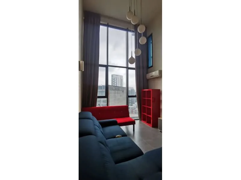 Living features: floor-to-ceiling windows, grey fabric sofa, red accent sofa, hanging pendant lights, air conditioning unit, curtains, light-colored flooring, city view; style: modern; view: city.