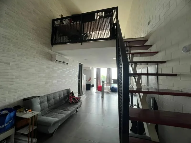 Living features: grey fabric sofa, metal staircase, white painted walls, exposed brick wall, large windows with curtains, air conditioning unit, tile flooring, decorative cushions, coffee table, open loft area above; style: modern.
