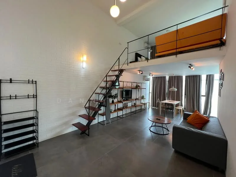 Living features: white painted walls, exposed brick wall, grey polished concrete flooring, 5-blade ceiling fan with light, large windows with sheer curtains, sofa in grey fabric, coffee table, TV console, wall-mounted TV, open shelving unit, decorative orange cushion, staircase with metal railing leading to loft area; style: modern. Room features: loft area with orange seating, recessed downlights.