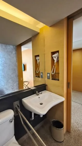 Bathroom features: wall-mounted sink, chrome faucet, toilet, hand dryer, mirror, grey stone wall, wood paneling, lighted ceiling, tiled flooring, waste bin; style: modern.