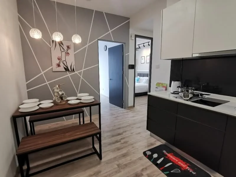 Kitchen features: black cabinetry, white countertop, built-in stove, stainless-steel sink, modern faucet, wooden dining table, bench seating, decorative wall with floral artwork, pendant lighting, laminate flooring, geometric wall design; style: modern.