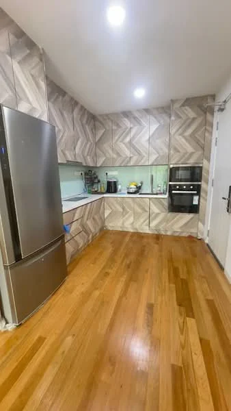 Kitchen features: stainless-steel fridge, built-in oven, wood cabinetry with herringbone pattern, light green backsplash, countertop with space for appliances, wooden flooring, recessed ceiling lights; style: modern.