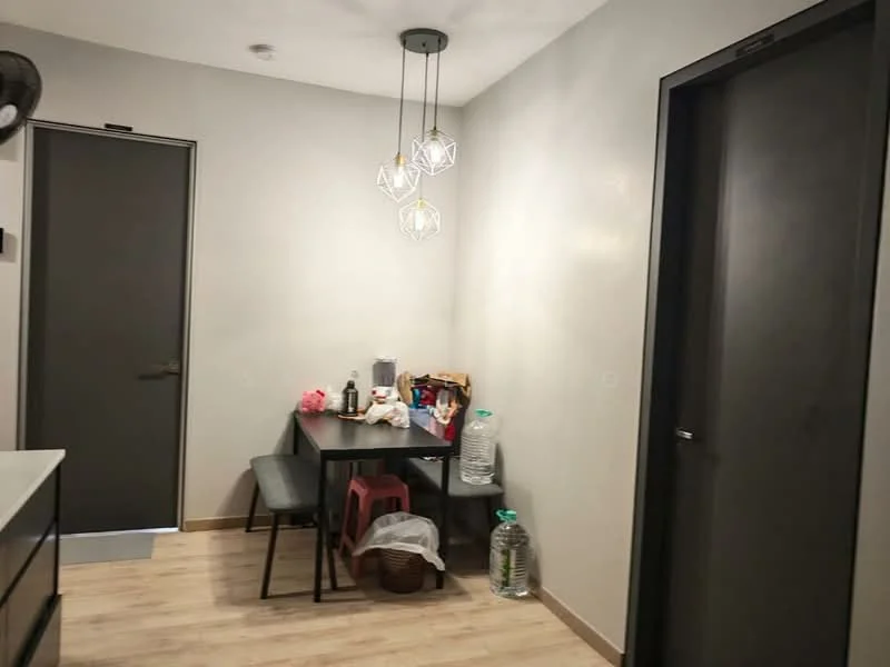 Dining features: wooden dining table, 4 black dining chairs, pendant lighting with geometric design, light grey painted walls, laminate flooring, door to hallway, door to another room, plastic stools, bottled water, various items on the table; style: modern.