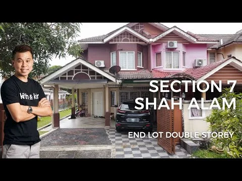 Exterior type: double-storey house; features: pink and cream painted facade, gabled roof, front porch with decorative columns, car porch with space for one car, manicured lawn, paved driveway, security gate, air conditioning units visible on the facade, surrounded by greenery; style: modern.