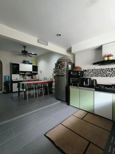 Kitchen features: green and white cabinetry, black countertop, stainless-steel fridge, built-in oven, 4-burner gas hob, black range hood, black and white mosaic tile backsplash, grey tile flooring, 5-blade ceiling fan, kettle, toaster, dishwasher, open shelving, decorative plants; style: modern. Dining features: 4-seater dining table, black dining chairs, water dispenser, open shelving, decorative items; style: modern.