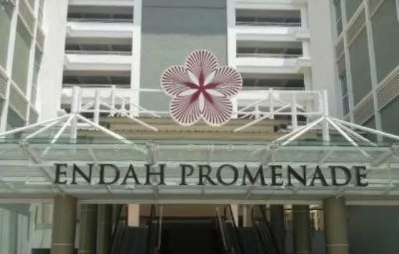 Exterior type: mid-rise condominium; features: glass entrance canopy, decorative flower motif, signage with 'ENDAH PROMENADE', multiple levels visible, white painted facade, balconies on upper levels, architectural detailing on facade; style: modern.