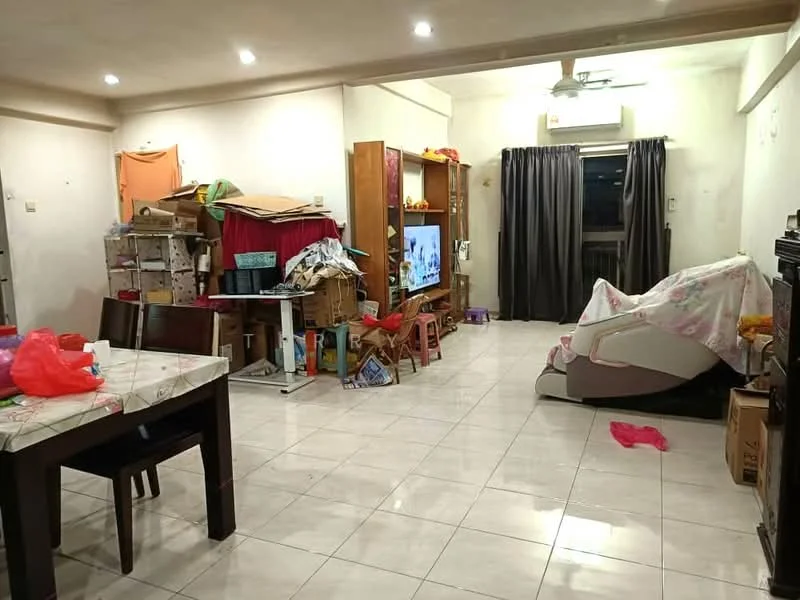 Living features: white painted walls, glossy tile flooring, 5-blade ceiling fan, recessed downlights, large window with black curtains, TV console, wall-mounted TV, sofa covered with fabric, dining table with chairs, boxes and clutter, decorative items on shelves.