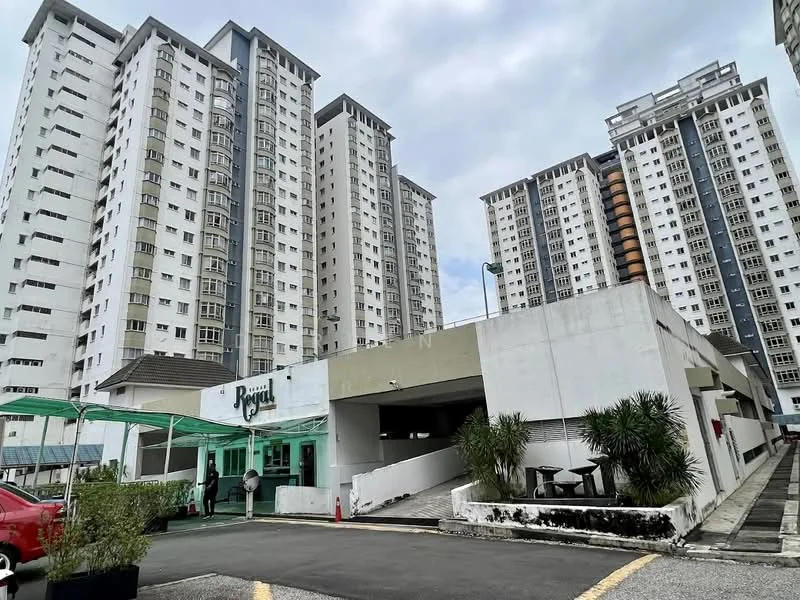 Exterior type: high-rise condominium; features: multiple high-rise buildings, white painted facade, green awning at entrance, landscaped area with plants, driveway leading to entrance, parking area visible, security features at entrance; style: modern.