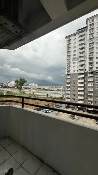 Room features: balcony with tiled flooring, metal railing, view of city skyline, overcast sky, adjacent building visible, roadway below, greenery in the distance; view: city.