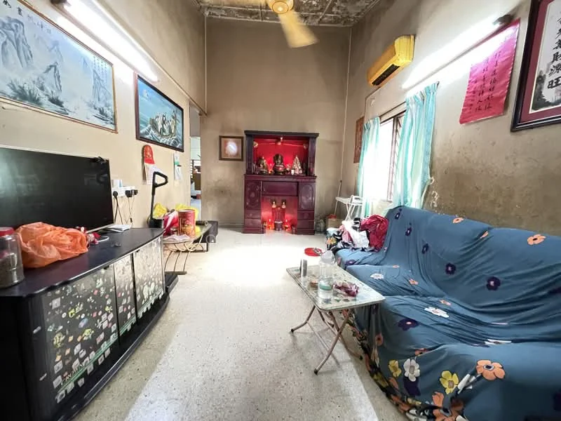 Living features: beige painted walls, exposed ceiling with texture, polished concrete flooring, 3-seater fabric sofa with floral pattern, coffee table, TV console, wall-mounted TV, decorative cabinet, window with sheer curtains, air conditioning unit, decorative altar, framed artwork on walls; style: traditional.