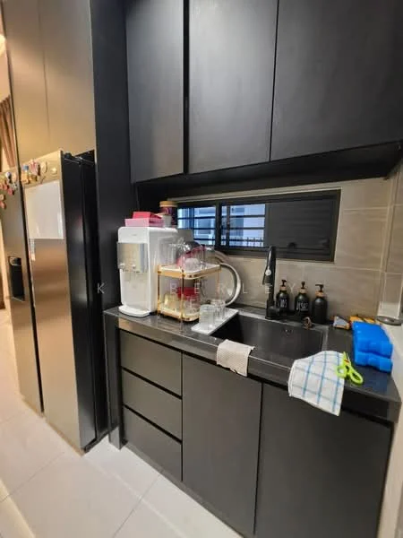 Kitchen features: black cabinetry, stainless-steel fridge, black countertop, single-bowl stainless-steel sink, chrome pull-down faucet, built-in water dispenser, glass window, grey tile backsplash, white dish towel, blue cleaning cloth, various bottles on countertop; style: modern.