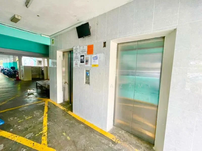 Exterior type: parking deck; features: elevator access, grey tiled walls, yellow painted lines on floor, concrete flooring, wall-mounted intercom panel, visible signage, parking area with motorcycles, overhead lighting; style: modern.