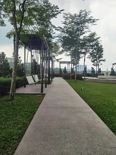 Exterior type: landscape garden; features: paved walkway, manicured lawn, swing benches, mature trees, landscaped greenery, open space, seating area, surrounding greenery; style: modern.