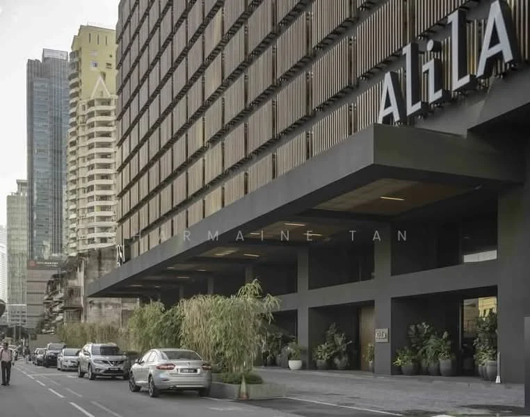 Exterior type: high-rise condominium; features: modern facade with horizontal wooden slats, glass curtain wall, prominent signage, multiple storeys, landscaped planters with greenery, open-air parking area, surrounded by urban skyline, street view with vehicles, concrete structure, large entrance area; style: modern.
