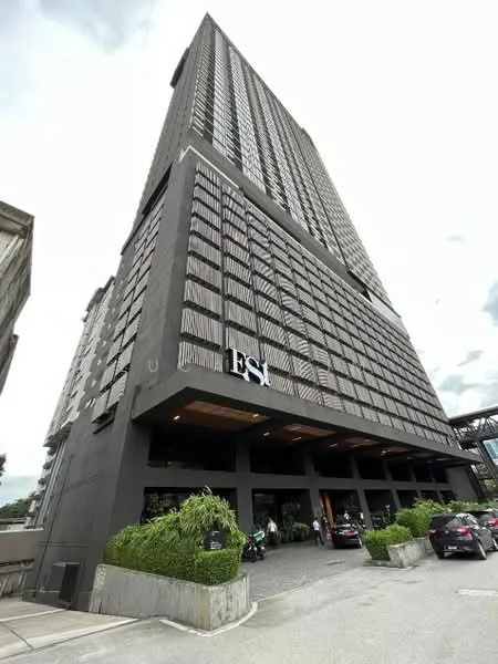 Exterior type: high-rise condominium; features: dark grey painted facade, wooden slat cladding, glass windows, approximately 20-storey high-rise, manicured landscaping, entrance with awning, visible parking area, modern architectural design; style: modern.