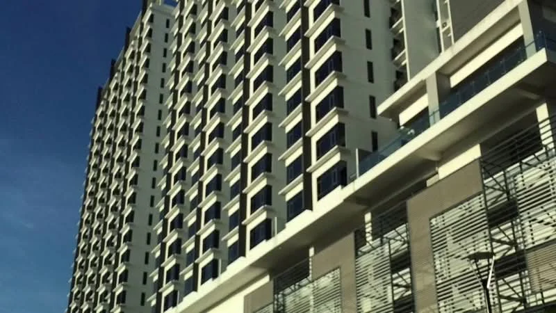 Exterior type: high-rise condominium; features: glass curtain wall, white painted facade, recessed balconies, vertical fins, multiple storeys, balconies with glass railings; style: modern.