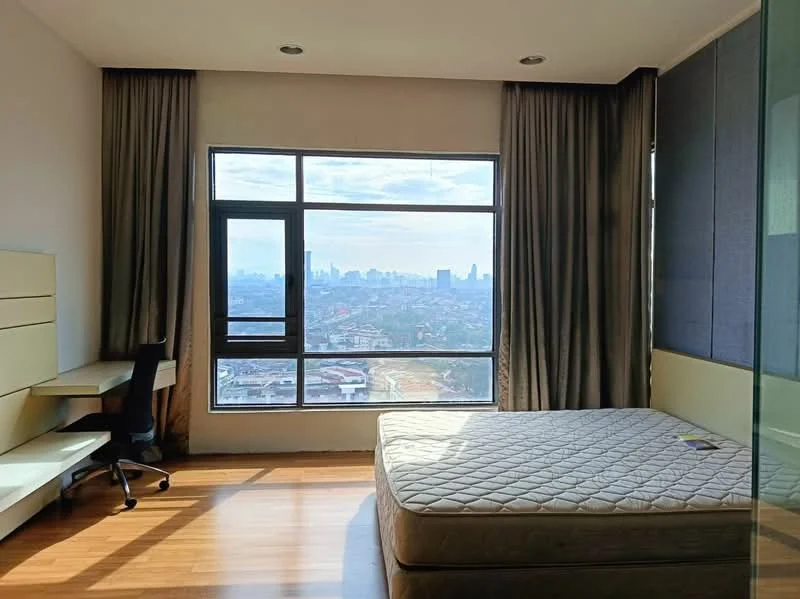 Bedroom features: large floor-to-ceiling window, city skyline view, light brown laminate flooring, cream painted walls, curtains, built-in desk with chair, unmade bed with mattress, recessed ceiling lights; style: modern; view: city.