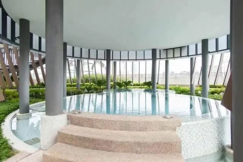 Exterior type: clubhouse; features: infinity pool, surrounding greenery, circular pool design, stone steps leading into pool, large windows, column supports, landscaped garden area; style: modern.