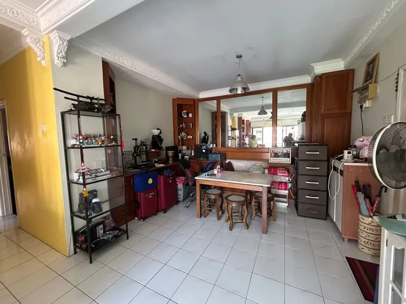 Dining features: white tiled flooring, yellow painted wall, wooden dining table, three wooden stools, glass display shelf, black storage cabinet, kitchenette with wooden cabinetry, recessed ceiling lights, wall-mounted fan, decorative items on shelf; style: modern.