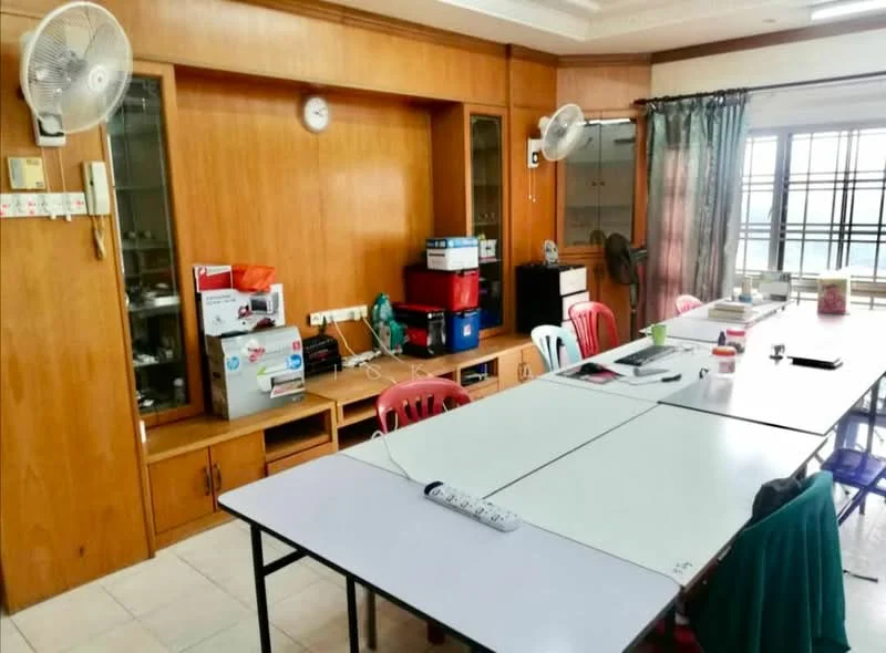 Room features: wood paneling on walls, white ceiling, tile flooring, large windows with grid pattern, curtains, multiple ceiling fans, long rectangular table, plastic chairs in red and white, built-in shelving unit, various appliances on shelves, clock on wall, power strip on table; style: modern.