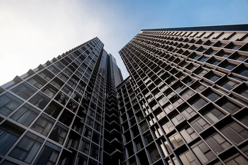Exterior type: high-rise condominium; features: glass curtain wall, dark grey facade, recessed balconies, vertical fins, approximately 30-storey high-rise, floor-to-ceiling windows, modern architectural design; style: modern.