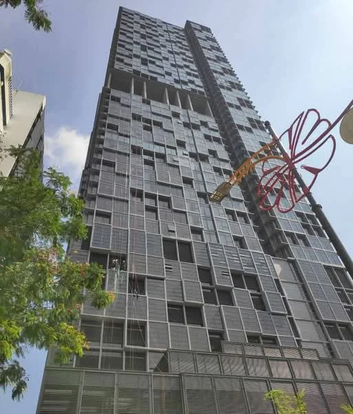 Exterior type: high-rise condominium; features: glass curtain wall, exposed concrete facade, recessed balconies, vertical fins, feature lighting at night; style: modern.