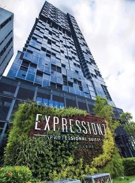 Exterior type: high-rise condominium; features: glass curtain wall, green wall with plants, signage with 'EXPRESSIONZ PROFESSIONAL SUITES', modern architectural design, multiple storeys, surrounded by greenery; style: modern.