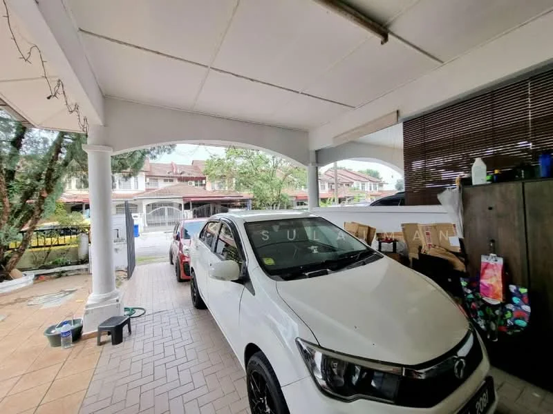 Exterior type: linked terrace house; features: covered car porch, white painted columns, tiled flooring, manicured lawn visible in background, driveway with interlocking pavers, outdoor lighting fixtures, wooden storage cabinet, decorative wall with wooden slats; style: modern.